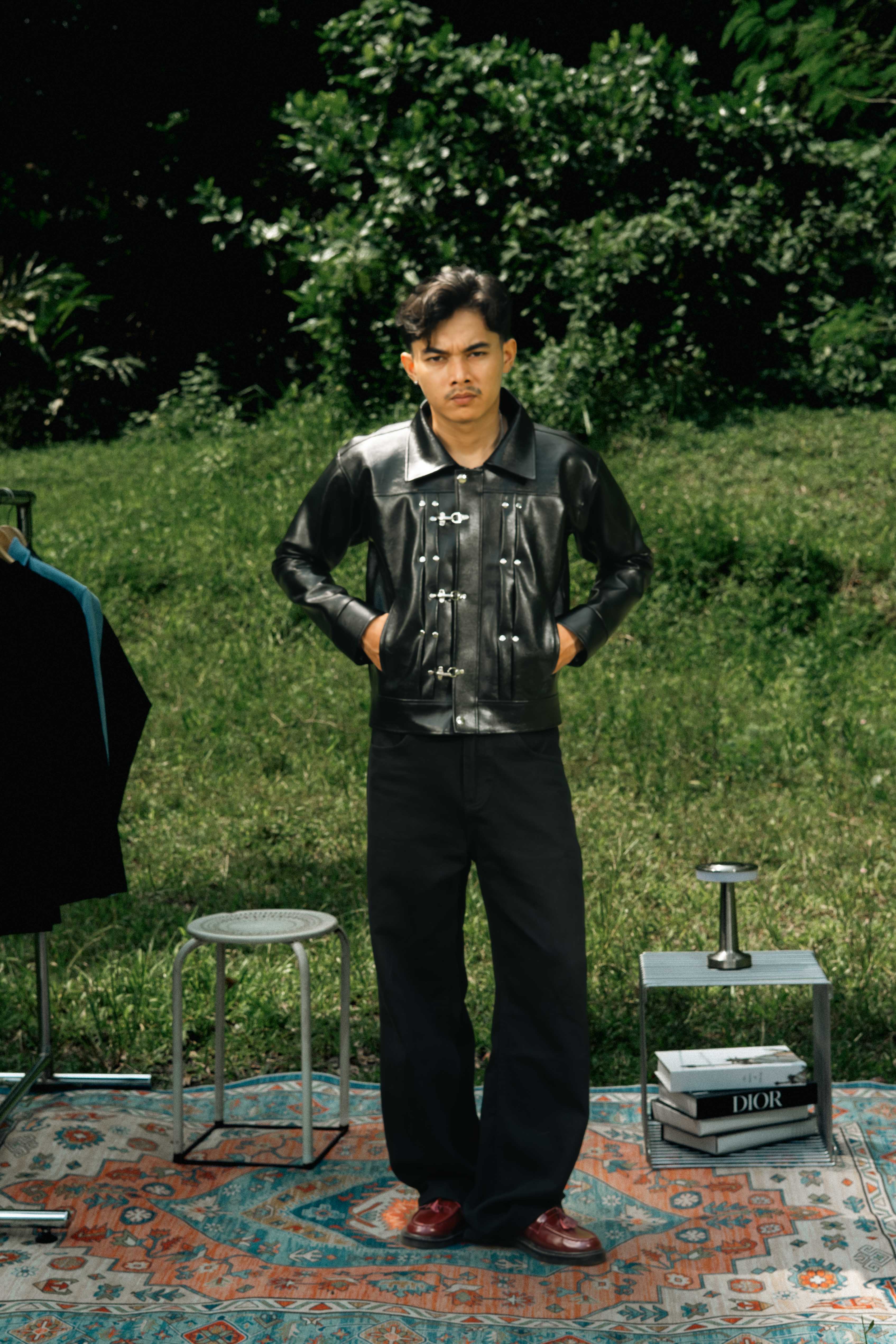 Minimalist black leather jacket with a bold fireman clsp closure and modern edge